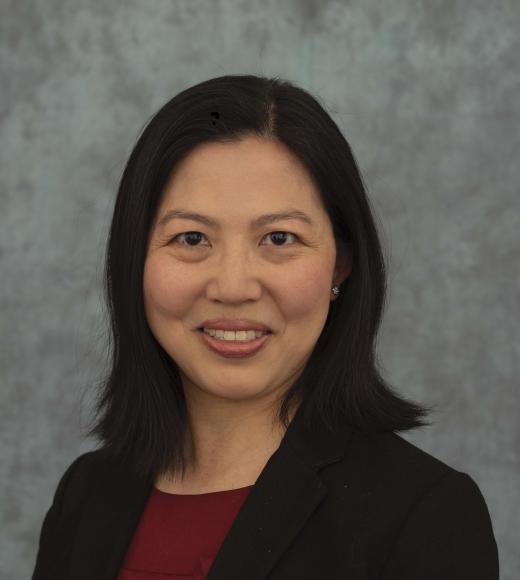 Asian woman with dark black hair wearing a red shirt with black blazer